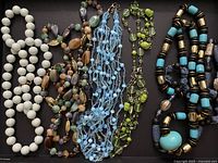 All five necklaces arranged on black background