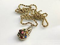 Full view of necklace showing rope chain and jeweled perfume bottle pendant