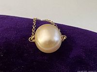Front view of pearl pendant on purple background