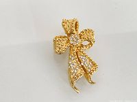 Front view of gold-tone bow brooch with rhinestones