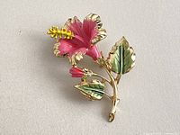 Front view of pink enamel hibiscus-style brooch