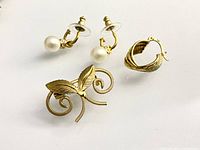 brooch, pearl earrings pair, single hoop earring displayed on white background