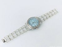 Full view of watch with clear lucite bracelet and blue dial