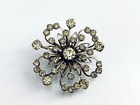 Front view of silver-tone floral brooch showing clear rhinestones arrangement