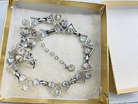 Necklace coiled in box showing full design and rhinestones