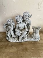 Front view of three-cherub birdfeeder statue showing figures and bowl