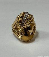 Front view of gold cameo ring showing woman’s profile and diamond accent row