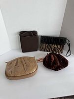 All four small handbags arranged together showing fronts and sizes