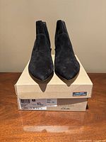 Front view of pair of Clarks Linvale Judith black suede shoes on original box showing condition and size label.