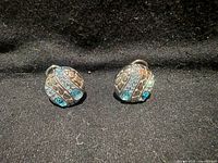 Front view of both rhinestone clip earrings on black background