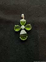 Front view of sterling silver pendant showing green stones and central cluster