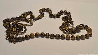 Full view of two-strand tiger's eye bead necklace laid flat