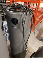 Cylindrical Surgically Clean Air Jade 2.0 air purifier with power cords placed on top