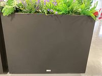 Single black rectangular planter divider with faux plants visible in top