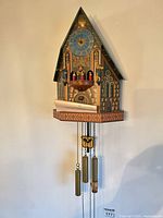 Full view of wall-mounted cuckoo clock with weights and pendulum