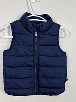 Front view of navy Baby Gap puffer vest showing zipper and quilting