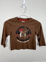 Front view of brown children’s T-shirt on hanger