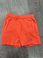 Front view of orange terry shorts showing overall condition and design