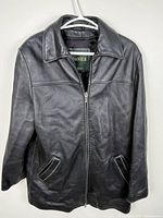 Full view of black leather jacket front on hanger