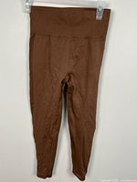 Front view of brown ribbed leggings hanging