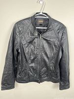 Front view of black leather jacket on hanger