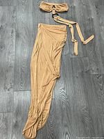 Bandeau top with O-ring and tie straps placed above matching maxi skirt on floor