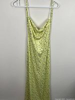 Front view of yellow floral slip dress hanging