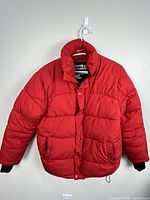 Front view of red Storm Mountain puffer jacket hanging