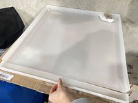 Top view of white plastic drain pan showing overall shape and raised edges