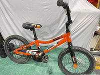 Full left-side view of orange and black Giant Animator kids bicycle