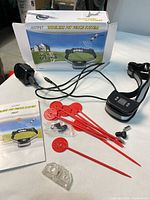 Full kit laid out including collar receiver, flags, charger, hardware, manual and box