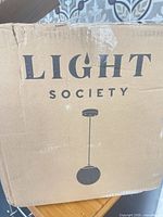 Shipping box with Light Society branding and product illustration