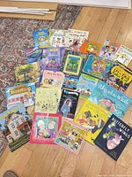Overhead view of approximately 24 children’s books laid out on floor