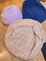 Three bean bag chairs grouped: lavender, blue, floral