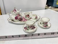 Complete tea set displayed with measuring tape for scale