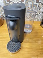 Front angled view of Nespresso VertuoPlus showing body, drip tray, water reservoir