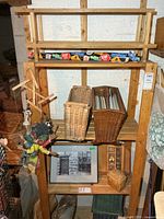 Overall lot on shelving showing shoe rack, baskets, marionette, print, small box, storage piece