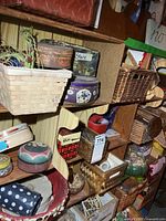 Wide view of three shelf levels showing baskets, tins, wooden spindles, pincushions and other small items