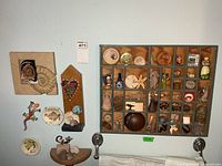 Overall view of wall-mounted shadow box, plaques and collectibles