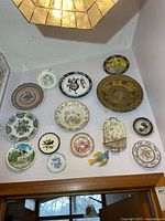 Overall view of wall showing assorted plates and brass charger