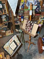 Overall view of wooden easel, music stand, green metal easel and wall art board
