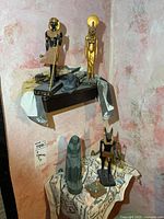 Overall view of both shelves showing seven Egyptian figures and objects