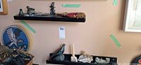 Shelf with multiple soapstone sculptures, resin candle holder and snowshoe