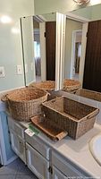 All three woven seagrass baskets on bathroom counter