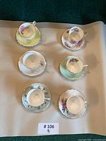 Six teacup and saucer sets laid out