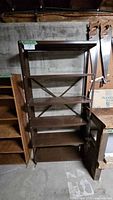 Full view of brown metal shelving unit with five shelves and cross brace