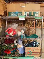 Shelf with boxed 3 ft Colorado table tree, bagged ornaments, grapevine sphere, green tree skirt, wreath, lights box