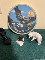 Front view of painted hand drum, Boma hunter sculpture, polar bear figure, seal figure