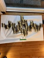 Full view of abstract metal wall sculpture on white paper