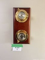 Full view of clock and barometer plaque on wall